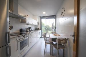 a kitchen with white cabinets and a table and chairs at Rincón del Naranjo in Olite