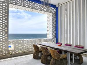 Un comedor con mesa y vista al mar. en Sofitel Tamuda Bay Beach And Spa, en M'diq