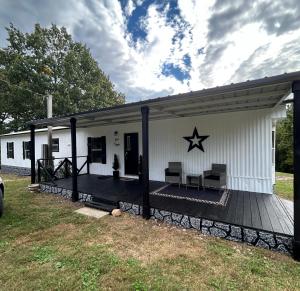 a white house with a deck with a star on it at The Ozark Stargazer in Western Grove