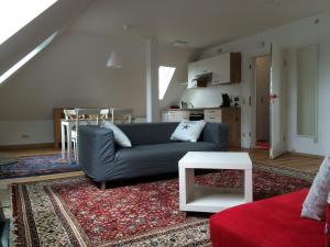 ein Wohnzimmer mit einem blauen Sofa und einem Tisch in der Unterkunft Villa Marie Mannheim in Mannheim