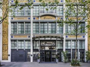 una fachada de un edificio con una tienda en Boutet Bastille Hotel Paris - MGallery Collection, en París