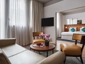 una habitación de hotel con un sofá y una cama en Boutet Bastille Hotel Paris - MGallery Collection, en París
