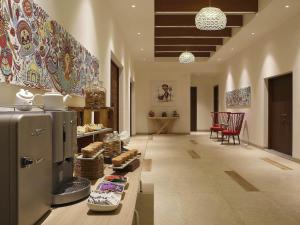 a kitchen with a refrigerator and a table with food at ibis Styles Goa Calangute - An Accor Brand in Calangute