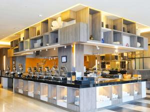 a kitchen with a long counter in a building at Novotel Pekanbaru in Pekanbaru