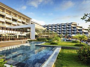 an exterior view of a hotel with a swimming pool at Novotel Phu Quoc Resort in Phu Quoc