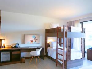 a bedroom with a desk and a bunk bed at Novotel Phu Quoc Resort in Phu Quoc