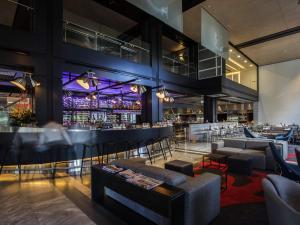 Un bar en un restaurante con sofás y sillas. en Pullman Sydney Airport, en Sídney