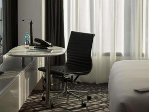 un escritorio y una silla en una habitación de hotel en Pullman Sydney Airport, en Sídney
