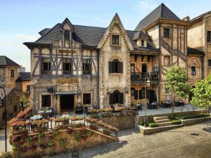 an old building with flowers in front of it at Mercure Danang French Village Bana Hills in Da Nang