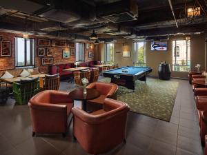 a billiard room with leather chairs and a pool table at Mercure Danang French Village Bana Hills in Da Nang