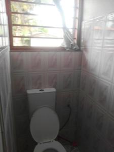 a small bathroom with a toilet and a window at Feel at home in Takoradi