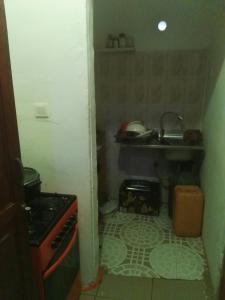 a small kitchen with a sink and a stove at Feel at home in Takoradi