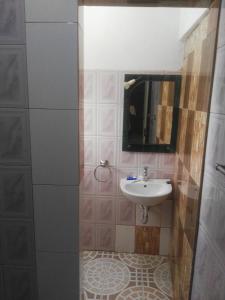 a bathroom with a sink and a mirror at Feel at home in Takoradi