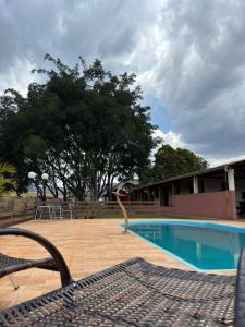 un banco sentado junto a una piscina en Tríade Chalé da Canastra 1, en São Roque de Minas