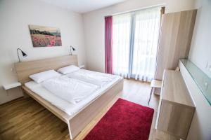 sypialnia z białym łóżkiem i czerwonym dywanem w obiekcie Öregtölgy Vendégház w mieście Szár
