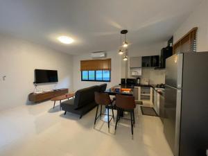 een keuken en een woonkamer met een koelkast en een tafel bij Casa Phangan in Wok Tum