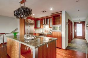 a kitchen with red cabinets and a marble counter top at Seaside in Cardiff-by-the-Sea