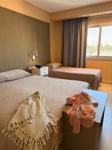 a hotel room with two beds and a table at Hotel Alvarado Suites in Salta +71 photos