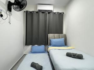 two beds sitting next to each other in a room at J&Y Homestay Kluang in Kluang