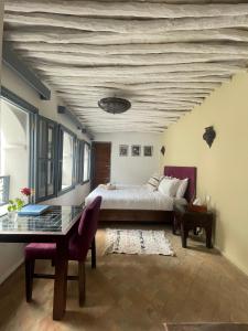 a bedroom with a bed and a desk and a table sidx sidx sidx at Riad Narjiss in Rabat