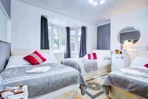 a bedroom with two beds and a mirror at Northwest Apartment in London