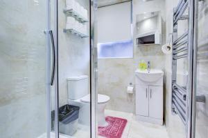 a bathroom with a toilet and a glass shower at Northwest Apartment in London +14 photos