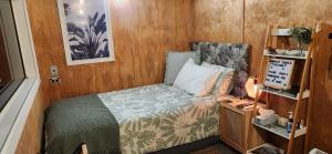 a small bedroom with a bed and a desk at Minimalist Cabin Solo Traveller in Ashburton