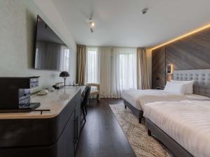 Una habitación de hotel con dos camas y un televisor. en Pullman Riga Old Town - Renovated 2025, en Riga 151 fotos más