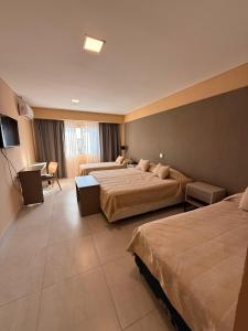 a hotel room with two beds and a television at Hotel Alvarado Suites in Salta