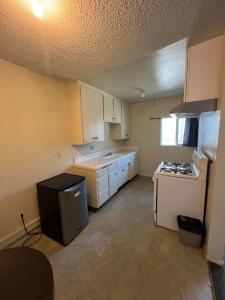 a kitchen with white cabinets and a stove top oven at York Motel in Los Angeles