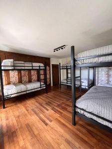 Habitación con 3 literas y suelo de madera. en TEROTERO Lake Hostel - Habitación Nahuel 2, en San Carlos de Bariloche