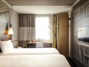 蒙蒂尼布勒托讷伊夫林省韦洛德罗姆圣康坦宜必思酒店的有两张床和一张书桌的酒店房间 更多85张照片