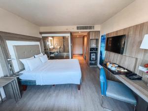 um quarto de hotel com uma cama grande e uma televisão em Novotel RJ Praia de Botafogo no Rio de Janeiro mais 173 fotografias