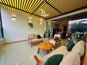 een woonkamer met een bank, stoelen en een tafel bij City Tower Hotel in Lima