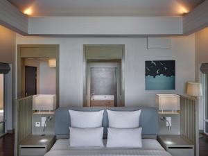 a room with a bed with three pillows at Pullman Phuket Panwa Beach Resort in Panwa Beach