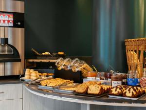 a buffet with different types of bread and pastries at Aparthotel Adagio Paris Malakoff Chatillon in Malakoff