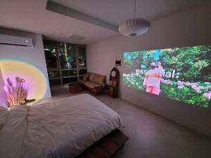 a bedroom with a bed and a large screen television at 슈기스테이 in Seoul