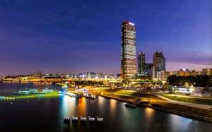 a city skyline with a tall building at night at 슈기스테이 in Seoul