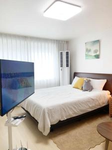 a bedroom with a large bed with a tv on it at Kinpark Stay 