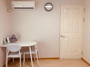 a table and chairs in a room with a clock on the wall at Kinpark Stay  +14 photos