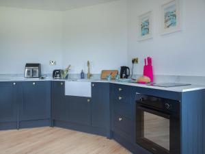 a kitchen with blue cabinets and a counter top at The Nest - Uk50122 in Bodelwyddan