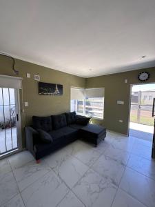 a living room with a black couch and a clock at Serena in Concepción del Uruguay