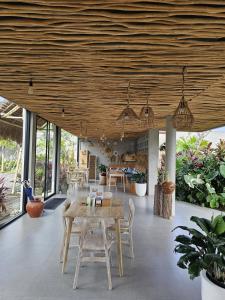 a dining room with a table and chairs and windows at Widji Garden Villa in Uluwatu
