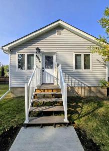 una casa con una escalera delante de una casa en The Oasis in Stettler, en Stettler