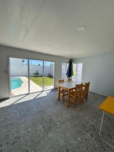a dining room with a table and chairs and a pool at Serena in Concepción del Uruguay