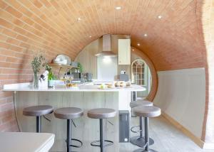a kitchen with a counter and stools in a room at Maesbury Den in Radstock