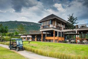 a golf cart parked in front of a house at Lala Mukha Tented Resort Khao Yai in Mu Si