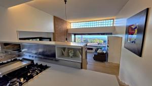 a kitchen with a stove and a living room at Rahal Luxury Between Etna & Sea - Heated Jacuzzi & Infinity Pool in Catania
