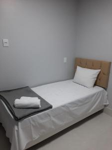 ゴイアニアにあるApartamento 1011の白い壁のドミトリールームのベッド1台分です。