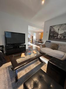 a living room with a flat screen tv and a couch at Serene Getaway Nordic Spa , Sauna, Nature & Pool in Rawdon